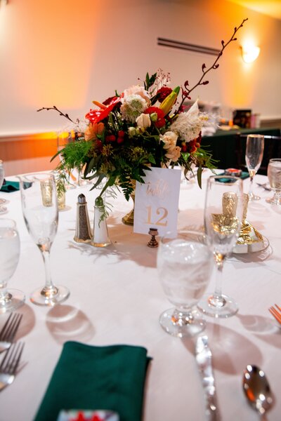 Picture of wedding table focused on wedding centerpiece (flowers) - UME (New England Wedding Planners) were part of the wedding day