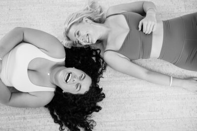 two women laughing laying on their backs