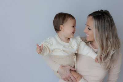 Mom holding baby smiling at each other