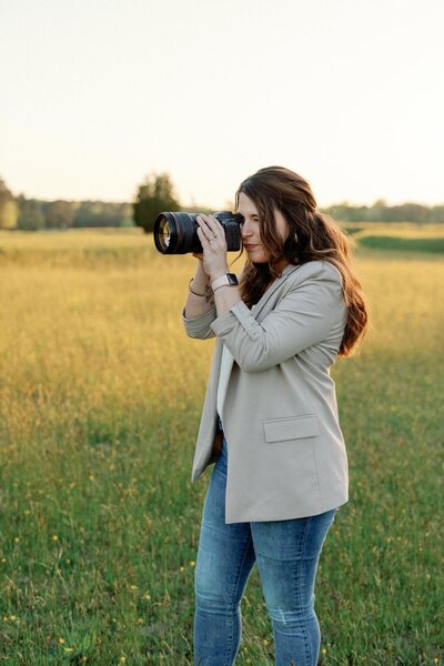 Woman holding a camera to take a photo.