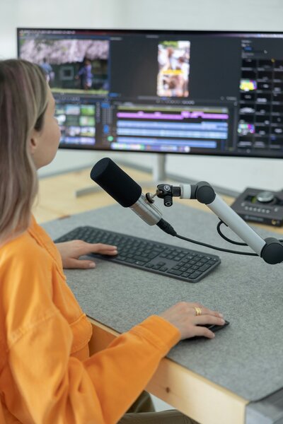 girl in orange jacket recording podcast