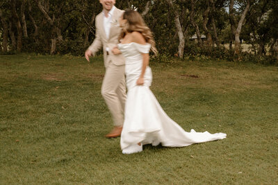 bride and groom running through the grass on wedding day in Colorado