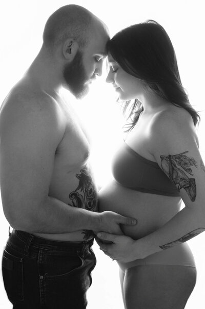 Couple expecting a baby girl posing for a maternity photoshoot in a studio photography in Austin