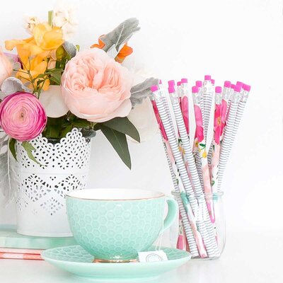 flowers in a vase,  pencils with pink erasers in a glass and a green tea cup