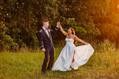photo of a bride laughing as she spins with the groom
