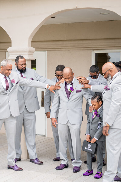 Groom and groomsmen smiling together wearing gray suits and purple accents – photographed by wedding photographer Niko Coric – Lumen Clarity Media