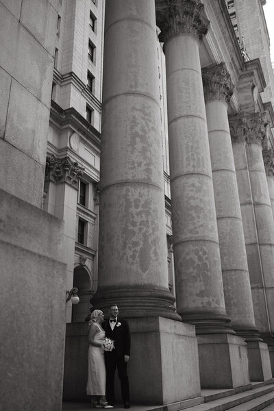bride and groom standing at city hall