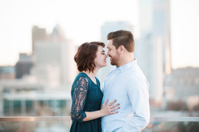 Engaged couple smiles nose to nose on a rooftop in downtown Tampa