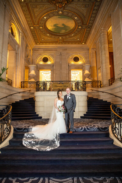 A classic wedding photo at gorgeous stairs and architecture at the Hilton Towers in Chicago, IL