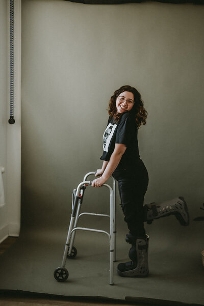 Portrait of Emily D'Angola wearing orthopedic boots and using walker