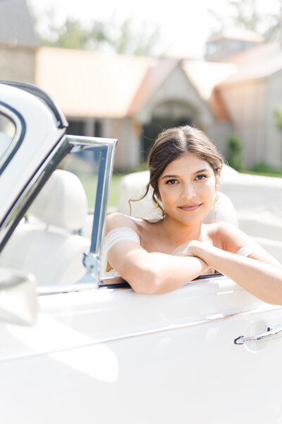 Casey sits in a classic VW on her Big Day. Her skin is perfect, her beauty natural. She glows.
