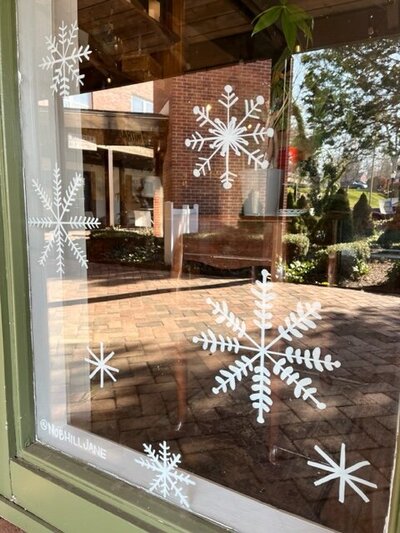 Hand drawn snowflakes on storefront windows of Cheshire, Connecticut business