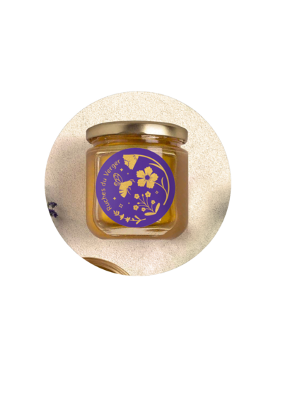 photo d'un pot de miel avec l'étiquette de mon projet Ruches du Verger. L'étiquette représente une abeille entourée de fleurs. L'abeille et les fleurs sont dorées  et elle sont sur un fond violet