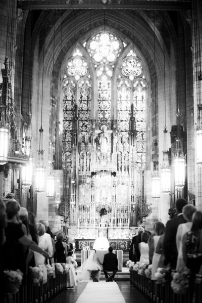 bride and groom sitting in front of the church altar during wedding ceremony in New York City