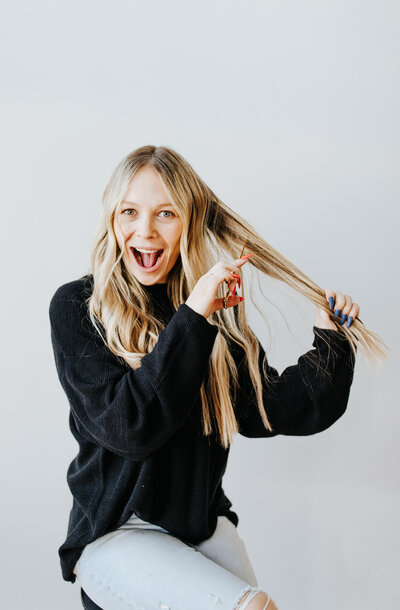 Kelsey hardin poses in a branding photo while cutting her hair