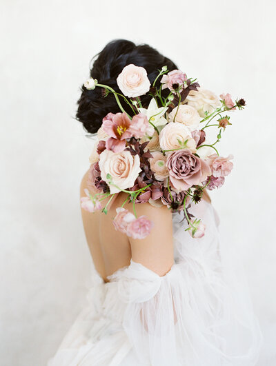 Bride with pink bouquet over shoulder
