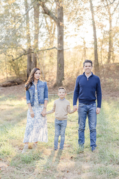 Mother son and dad holding hands and smiling. -Family Photographer Greenville SC