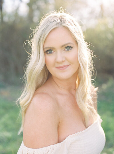 Headshot of Nashville newborn photographer Courtney Houk in white off the shoulder dress