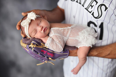 Newborn sleeping in dads baseball glove at her H&N photography photography session.