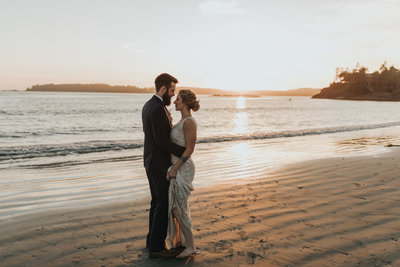 bride and groom on the beach dancing in the sunset light