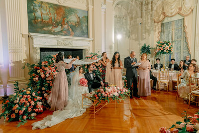 Couple and wedding guests together at Rosecliff Mansion in Newport, Unique Melody Events & Design (New England Wedding Planners) helped with event