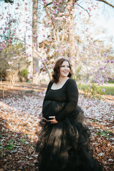Maternity pic of Victoria in a black tulle dress holding her baby bump in McCord Park, Tallahassee, Florida.