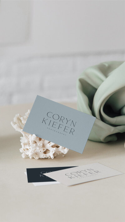 Coryn Kiefer business card on a piece of white coral