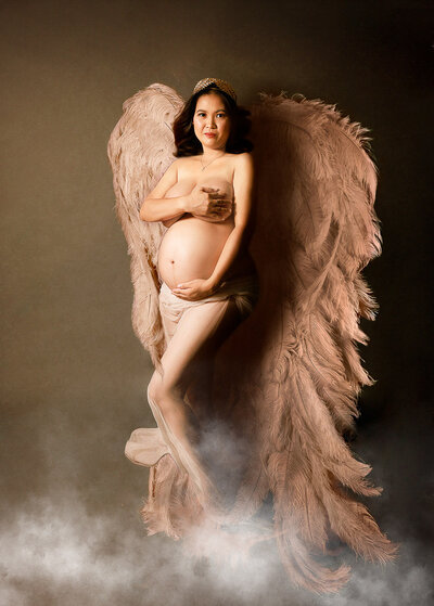 maternity photoshoot  wearing a feathered wings