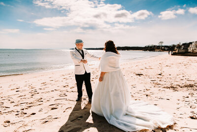 a photo of a  groom seeing his bride for their first look  in Rhode Island