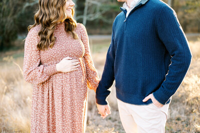 Expecting couple holds hands during maternity session by Worth Capturing in Raleigh, NC.