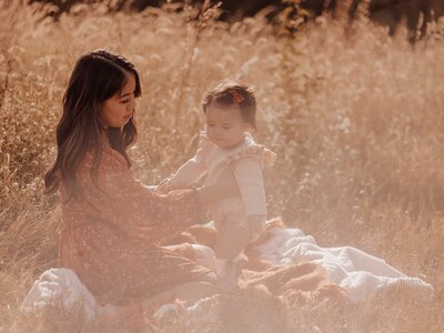 Outdoor photography session of a mother and child sitting on a blanket