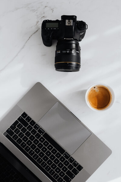 kaboompics_Coffee, laptop and camera on a white marble table