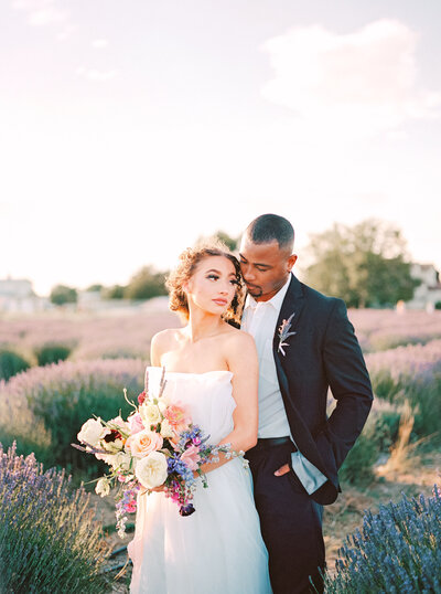 bride and groom in posing in lavender field at Araceli Farms holding colorful wedding bouquet with roses and lavender, photo by Anastasiya Photography - San Francisco Wedding Photographer
