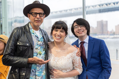 A bride and groom posing with a celebrity.