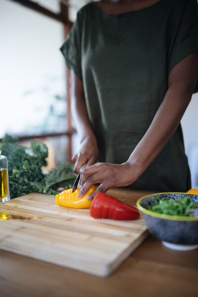 Woman chopping up peppers on a chopping board