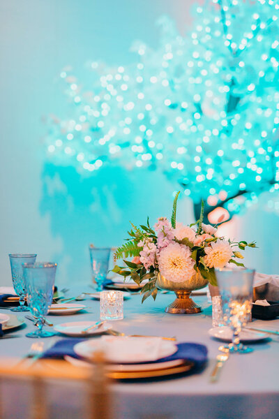 Details of a blue reception table set up with floral centerpiece