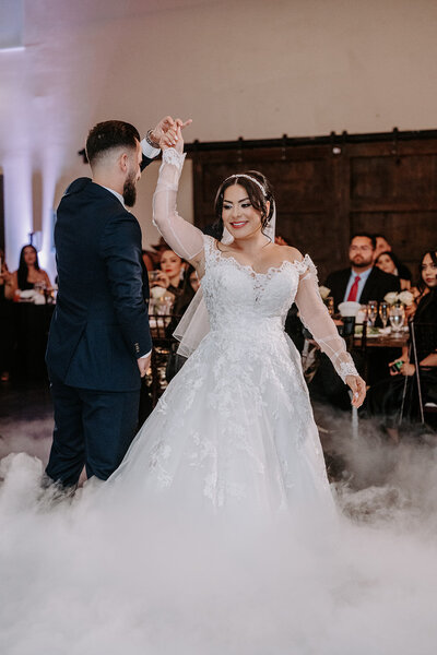 bride and groom dancing looks like they are on a cloud with dry ice and fog machine