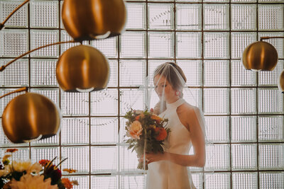 A bride gazes down at her bouquet