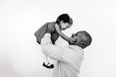 Dad holding his daughter in the air