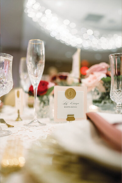 Blush and white place card adorned with a gold wax seal, elegantly displayed for this 50th anniversary celebration.