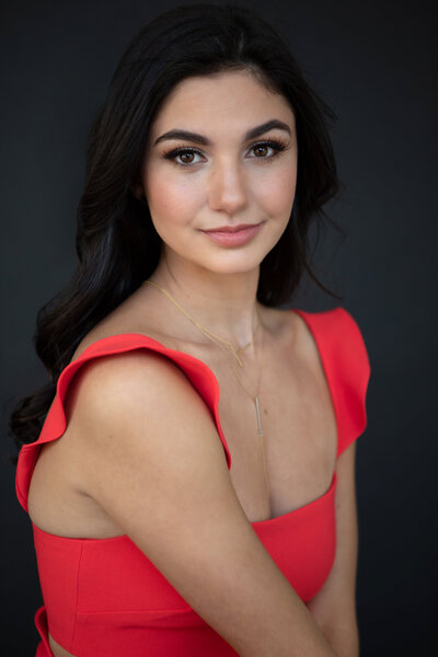 Beauty portrait of high school senior smiling in a red dress