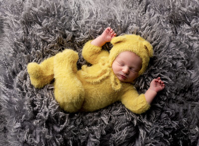 A sleeping baby boy dressed as winnie the pooh.