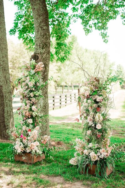 Two piece lush floral arbor covered in white, ivory, pink and blush flowers and greenery