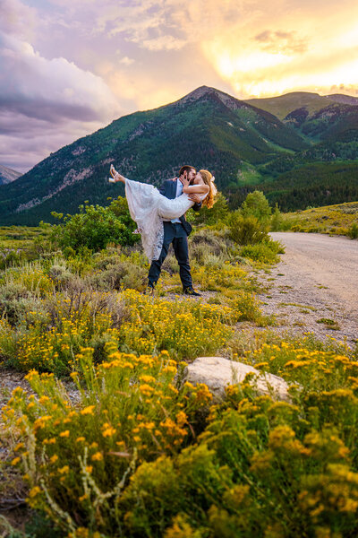 Bride and groom standing in a field at sunset with mountain views during their Buena Vista, Colorado elopement.
