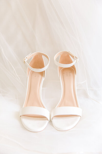 simple elegant white open toed wedding shoes on veil