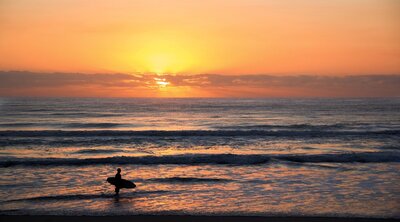 Surfer riding waves during a golden sunset in Puerto Escondido, Mexico—capturing the vibrant energy and beauty of this iconic surf destination.