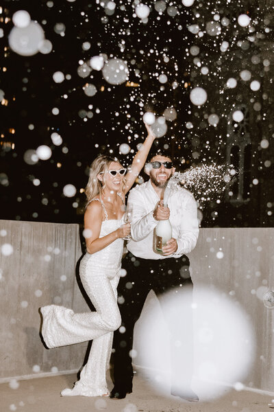 Couple spraying champagne for their wedding on a rooftop in Philadelphia PA