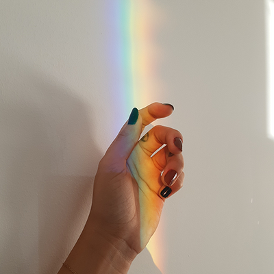 rainbow beam of light over a hand