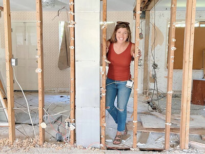 woman smiles at camera from house renovation