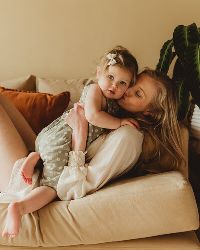 mother and little girl hugging sofa